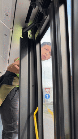 Boy peers from bus door in Belgrade suburb