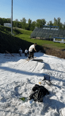 Man snowboards artificial slope in sunny Krasnoyarsk summer day