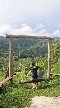 Log swing on a hillside overlooking northern Thailand's green valleys