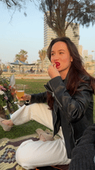 Woman enjoys outdoor meal on patterned mat