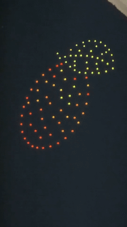 Drone light show displays pineapple, text in Sofia evening sky
