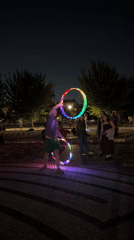 Rainbow LED hula hoops light up a Brooklyn park at night