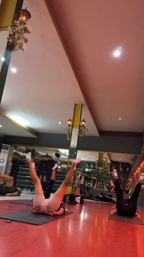 Yoga class underway at a red-floored studio in Kuta