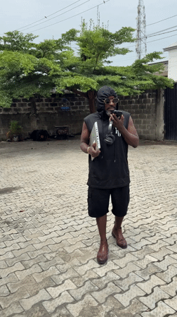 Man with laptop conducts phone call in Ado, Nigeria
