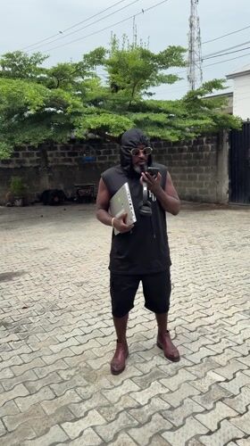 Man with laptop conducts phone call in Ado, Nigeria
