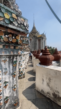 Tourist documents ornate walkway at Bangkok's Temple of Dawn