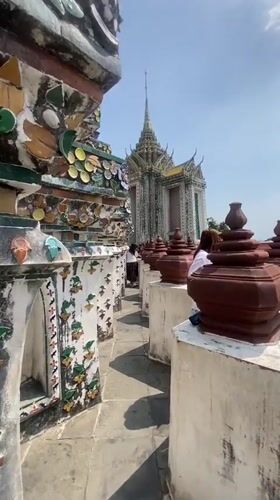 Tourist documents ornate walkway at Bangkok's Temple of Dawn