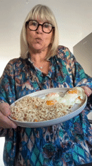 Woman holds food plate in Chambœuf kitchen