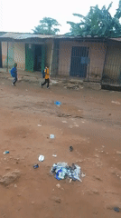 School-uniformed kids and locals moving through a dusty rural area