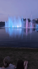 Pink-lit fountain display at dusk on a Mahilyow lake