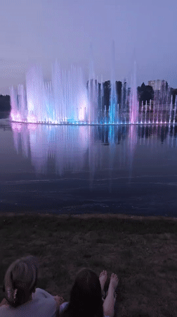 Pink-lit fountain display at dusk on a Mahilyow lake