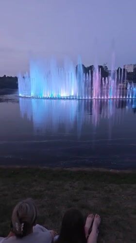 Pink-lit fountain display at dusk on a Mahilyow lake