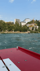 On the Rhine near Neuhausen, a boat crosses choppy green water