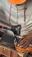 Tailor operates vintage sewing machine on stairs in Nigeria