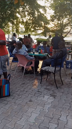 Men celebrate birthday gathering outdoors in Lokoja, Nigeria