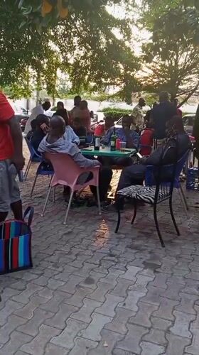 Men celebrate birthday gathering outdoors in Lokoja, Nigeria