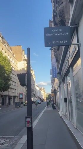 Street-level Paris: church, wet pavement, and Haussmann facades