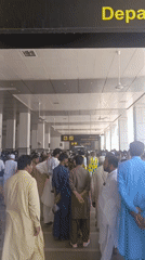 Families in traditional dress navigate Peshawar airport terminal