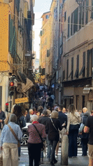 Crowd walks through narrow street in Sanremo, Italy