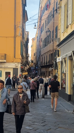 Crowd walks through narrow street in Sanremo, Italy