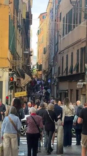 Crowd walks through narrow street in Sanremo, Italy