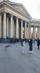 Woman photographs child at columned building in Saint Petersburg