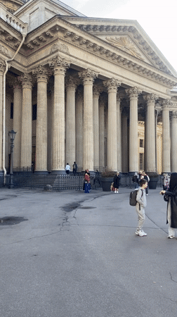 Woman photographs child at columned building in Saint Petersburg