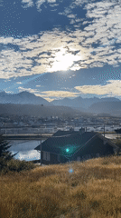 Helicopter flies over Ushuaia bay amid mountain scenery