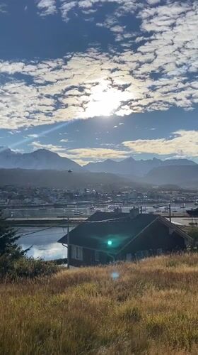 Helicopter flies over Ushuaia bay amid mountain scenery
