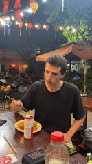 Man dining outdoors captured in Đà Nẵng street scene