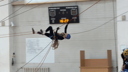 Person practices aerial rope training in gymnasium