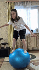 Girl practices balance exercises with pets at Russian home