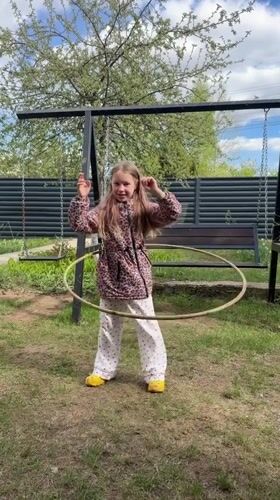 Girl plays with hula hoop in Russian backyard