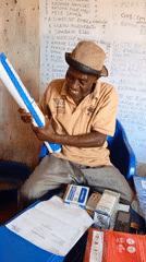 Elderly man conducts paperwork session in Ngalula office