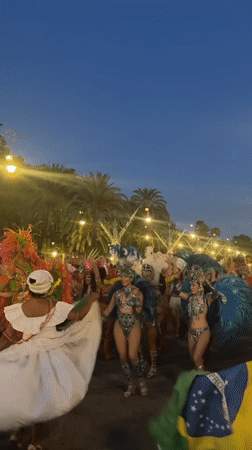 Carnival parade rolls through Barcelona streets at dusk