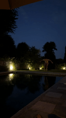 Nighttime pool jump at an illuminated outdoor pool in Angera