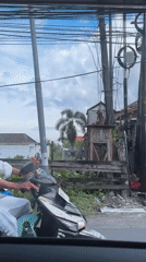 Traditional-dressed man rides scooter in North Kuta, Bali