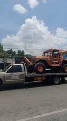 Tow trucks transport multiple off-road vehicles through Tinaquillo streets