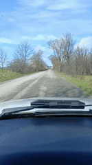 Vehicle travels deteriorated road in rural Bulgaria morning drive