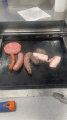 Mixed meats cooking on griddle in Guissona, Spain