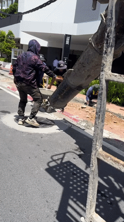 Street construction crew works Patong sidewalk on sunny morning