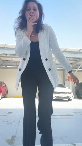 Woman smokes, poses in Dubai parking garage