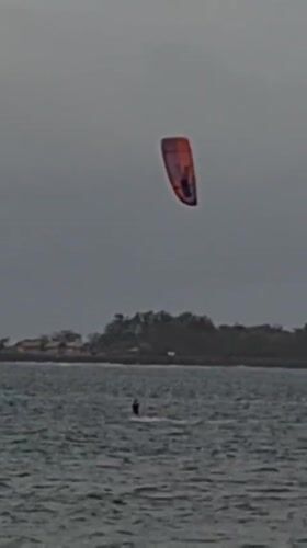 Kitesurfers ride choppy Bali waters under stormy skies