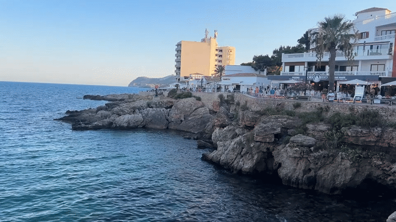 Sunny afternoon on Cala Rajada's promenade, cat included