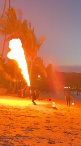 Fire performers light up a Ko Samui beach at dusk