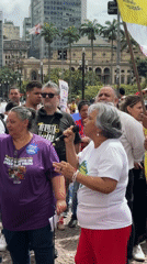 Protesters march through São Paulo streets with signs, flags