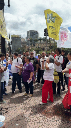 Protesters march through São Paulo streets with signs, flags