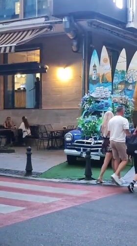 Decorated vintage Volga parked outside Batumi café amid contrasting architecture