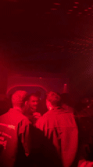 Late-night clubgoers captured amid red blue lighting display NYC