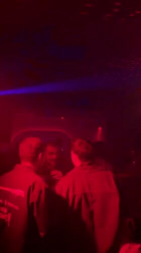 Late-night clubgoers captured amid red blue lighting display NYC